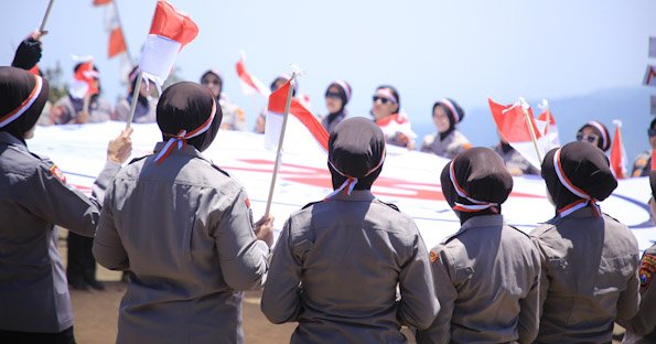 Hari Jadi ke-76, Polwan Polres Madiun Kibarkan Merah Putih dan Bendera Polwan di Puncak Bukit Mongkrang